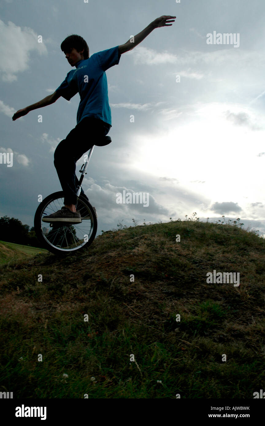 Off-road unicyclist silhouetté contre soir nuages de tempête Banque D'Images