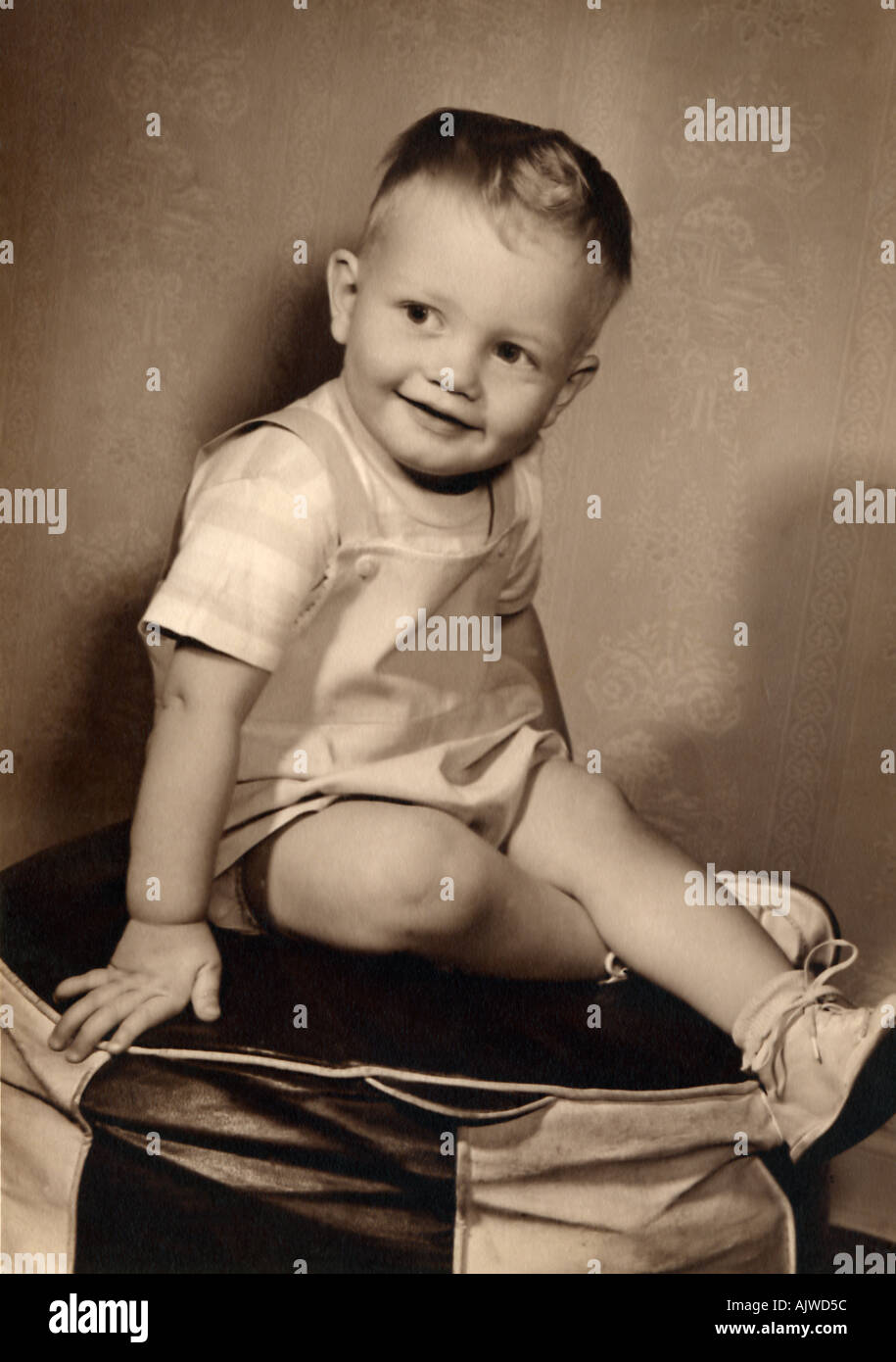 1950 s portrait d'un jeune garçon assis sur un pouf Banque D'Images