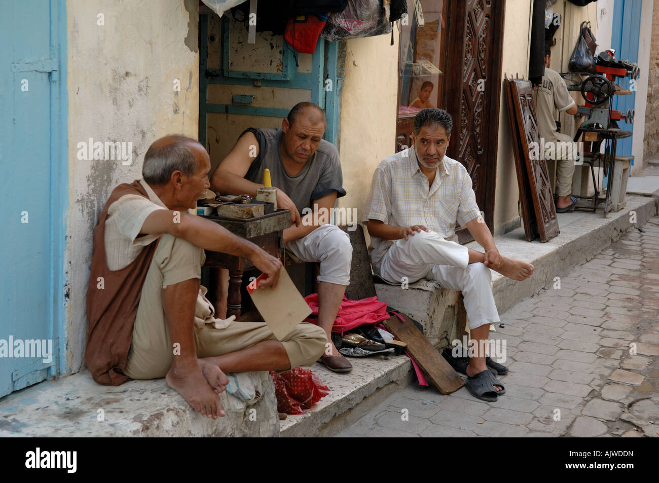 Groupe d'hommes discutant l'extérieur d'un magasin de cuir à Kairouan Tunisie Banque D'Images