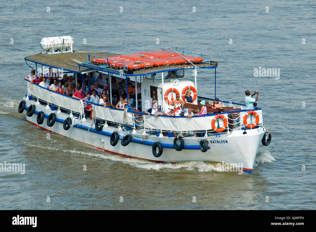 Close up horizontale de bateau flottant sur la rivière Thames rempli de touristes profitant d'une visite guidée de Londres. Banque D'Images
