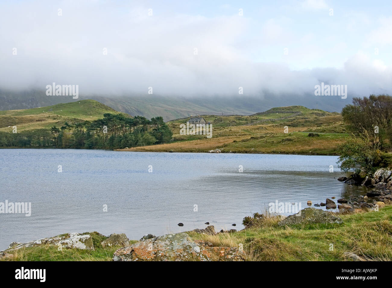 Vue vers la montagne Cadair Idris couvert de nuages à travers Llynnau Creggenen dans le lac Snowdonia. Banque D'Images