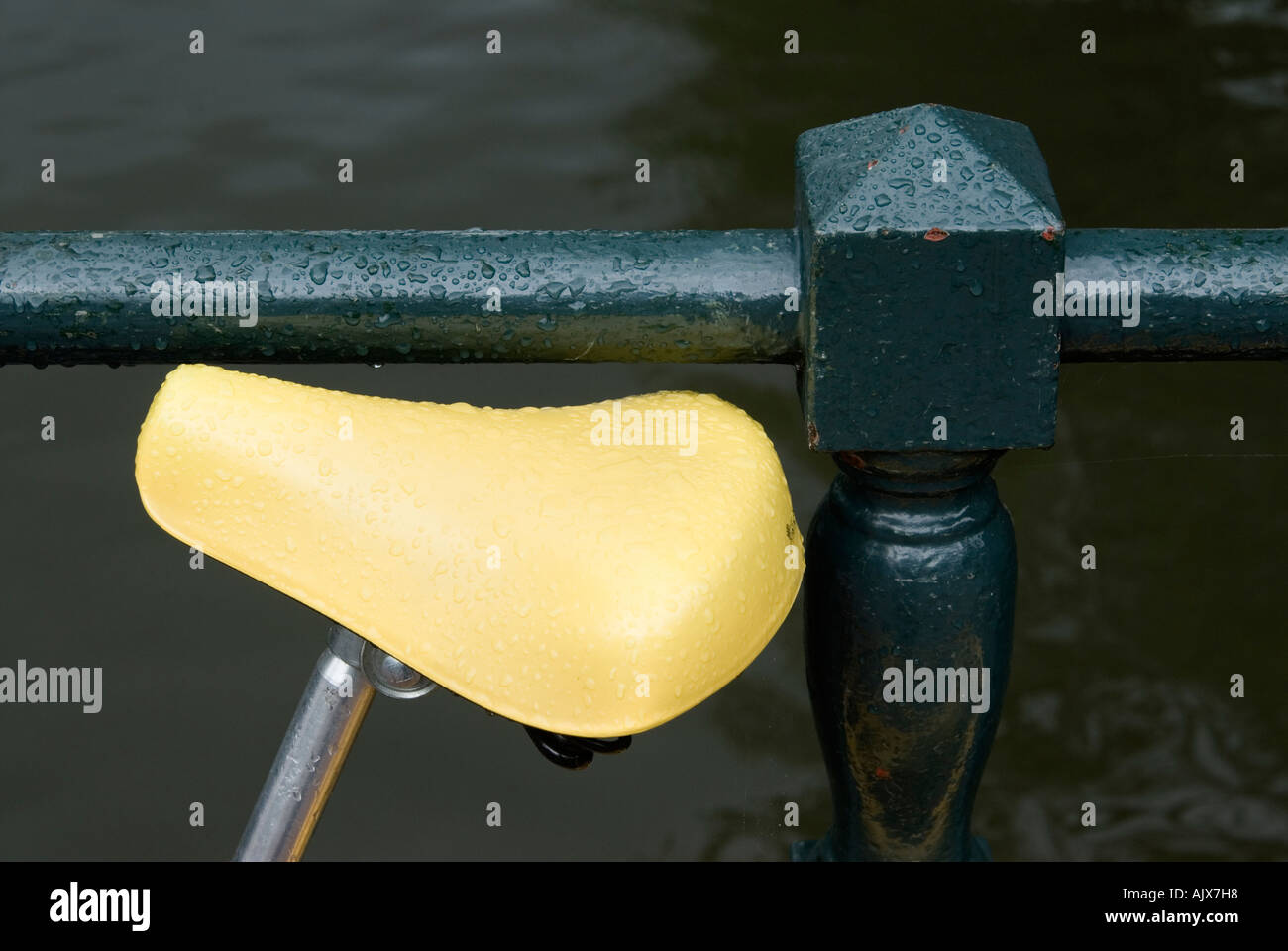 Selle de vélo jaune vif contre green pont-canal railing Amsterdam Hollande Pays-bas Europe Banque D'Images