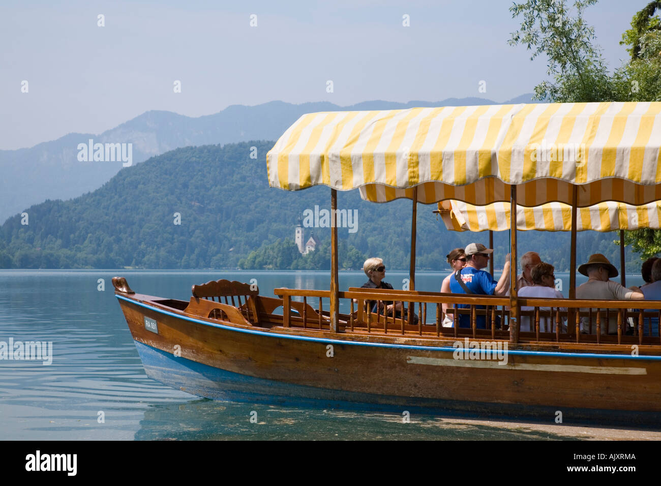 Le lac de Bled en été avec les touristes en pletnja en bois traditionnel en bateau d'aviron de l'église St Mary de l'île. Bled en Slovénie. Banque D'Images