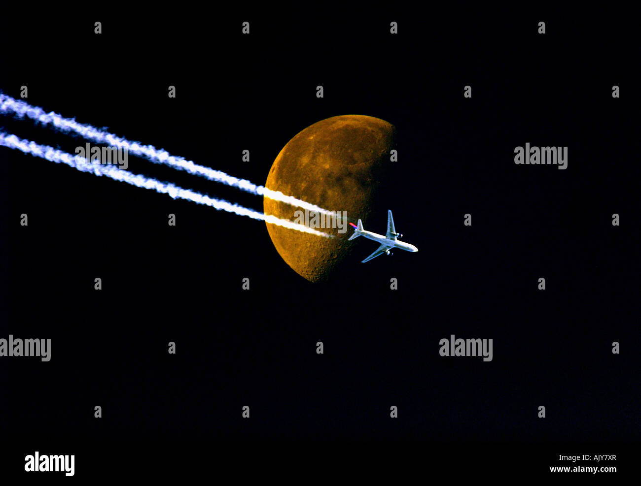 Un avion passe la lune dans le ciel au cours d'une soirée de fin d'été Banque D'Images