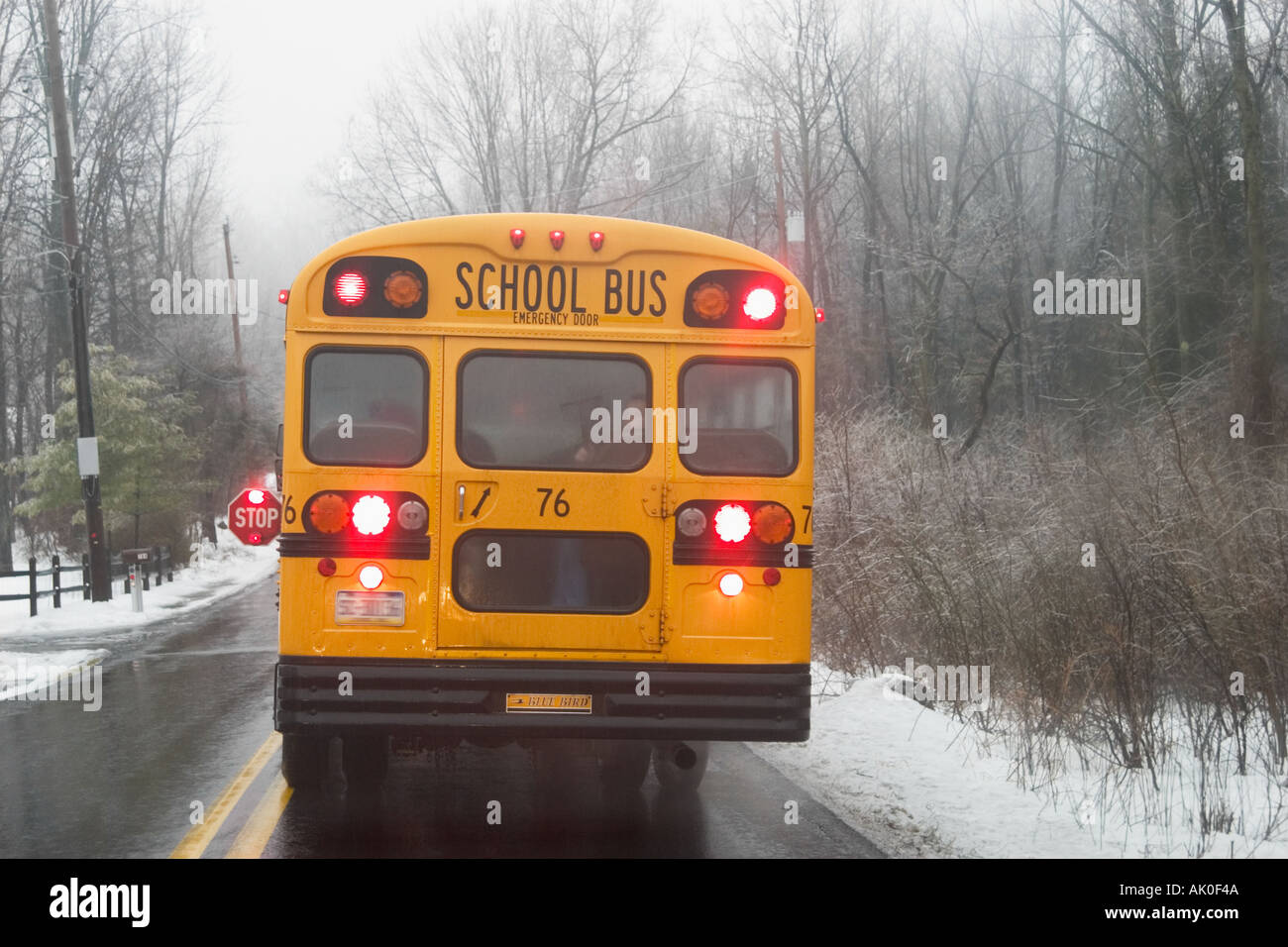 Autobus scolaire arrêté sur route mouillée des pluies Banque D'Images