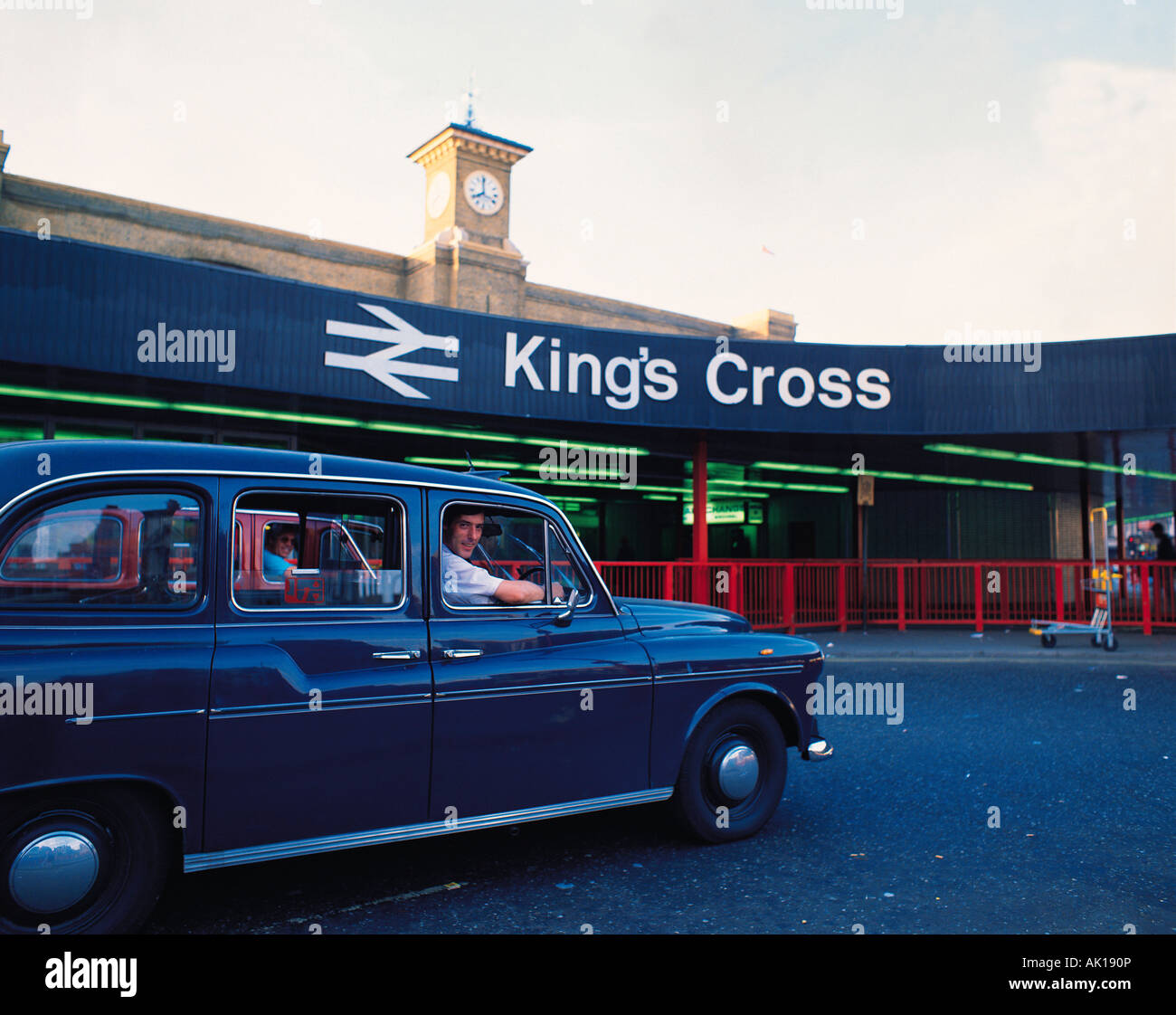 United Kingdom. L'Angleterre. Londres. La gare de Kings Cross. Chauffeur de taxi à côté de fenêtre de son taxi noir. Banque D'Images
