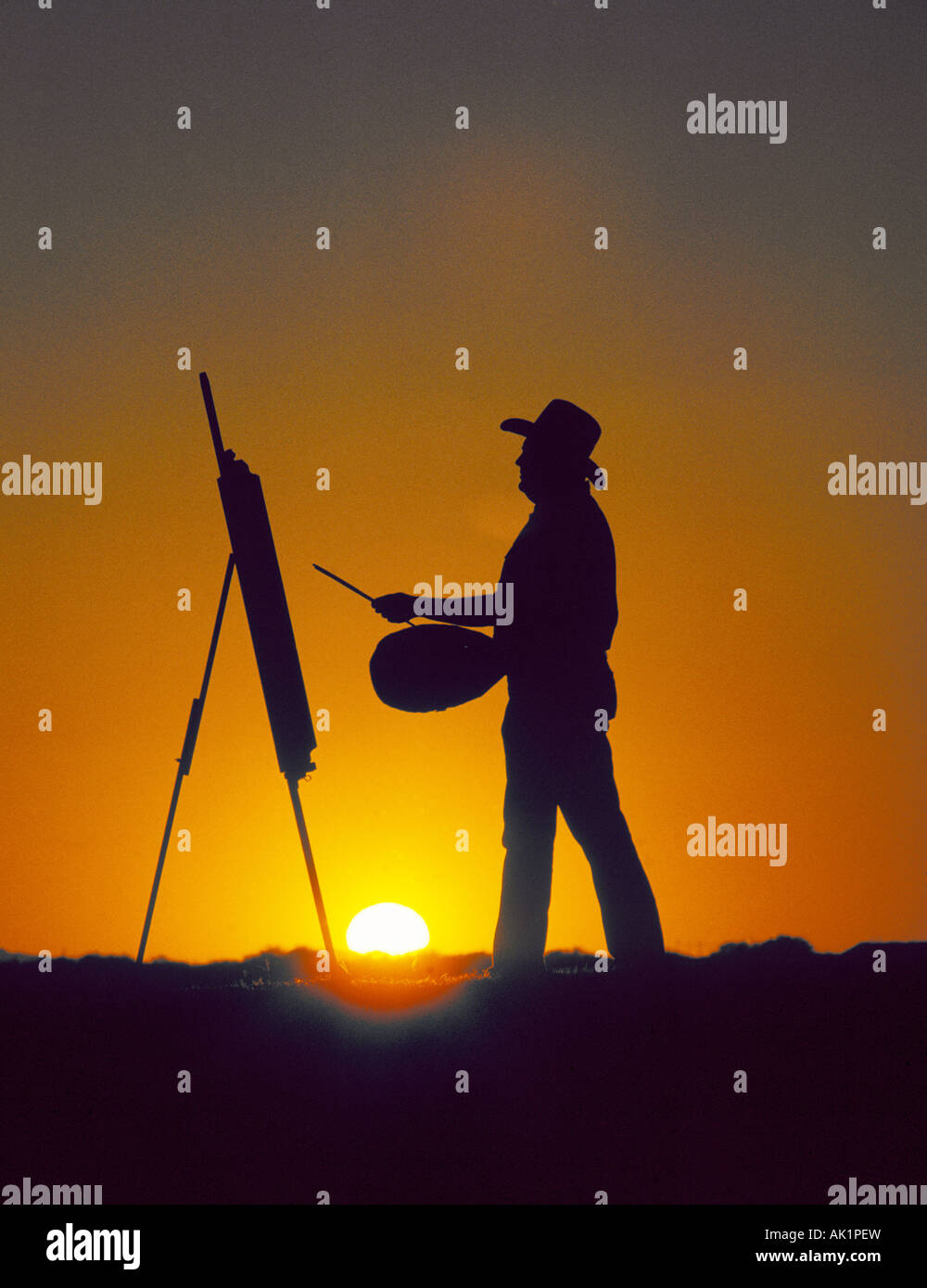 Un cowboy artiste peint une scène au coucher du soleil dans le désert près de Sedona Banque D'Images