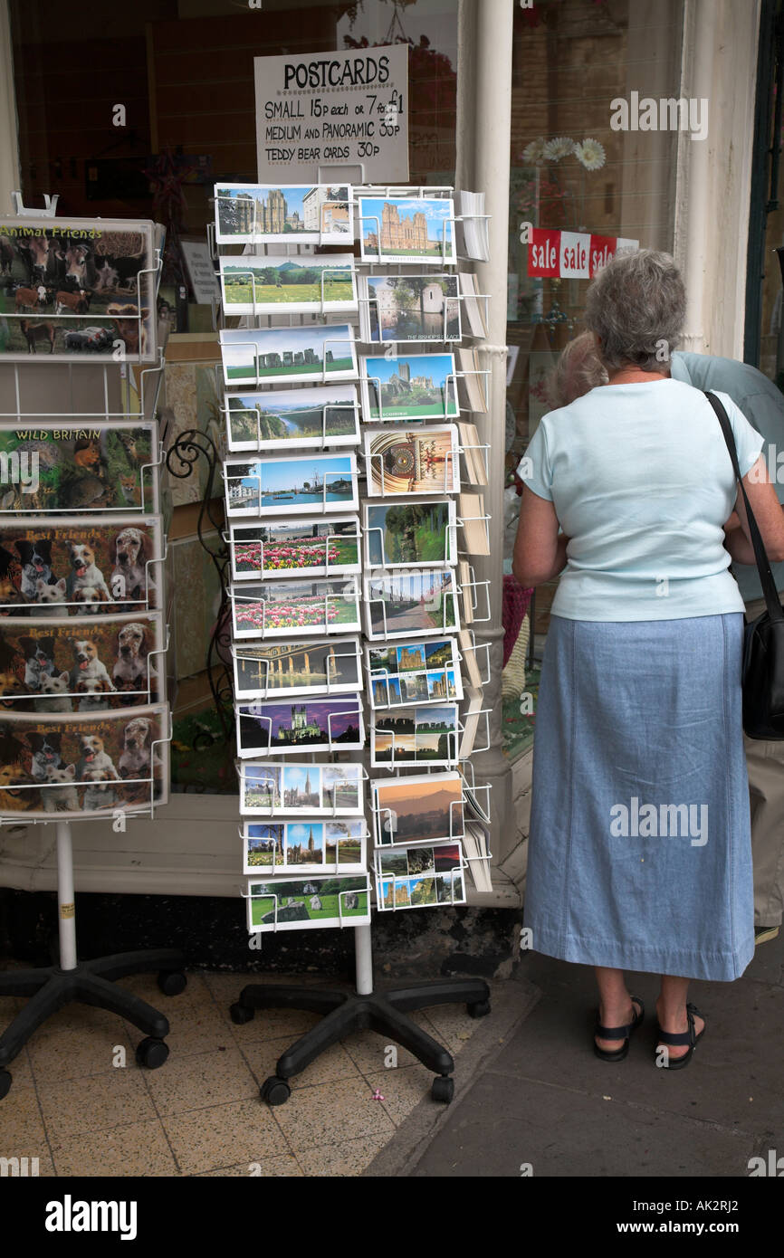 Woman et une carte postale de présentoir Wells, Somerset, Angleterre Banque D'Images