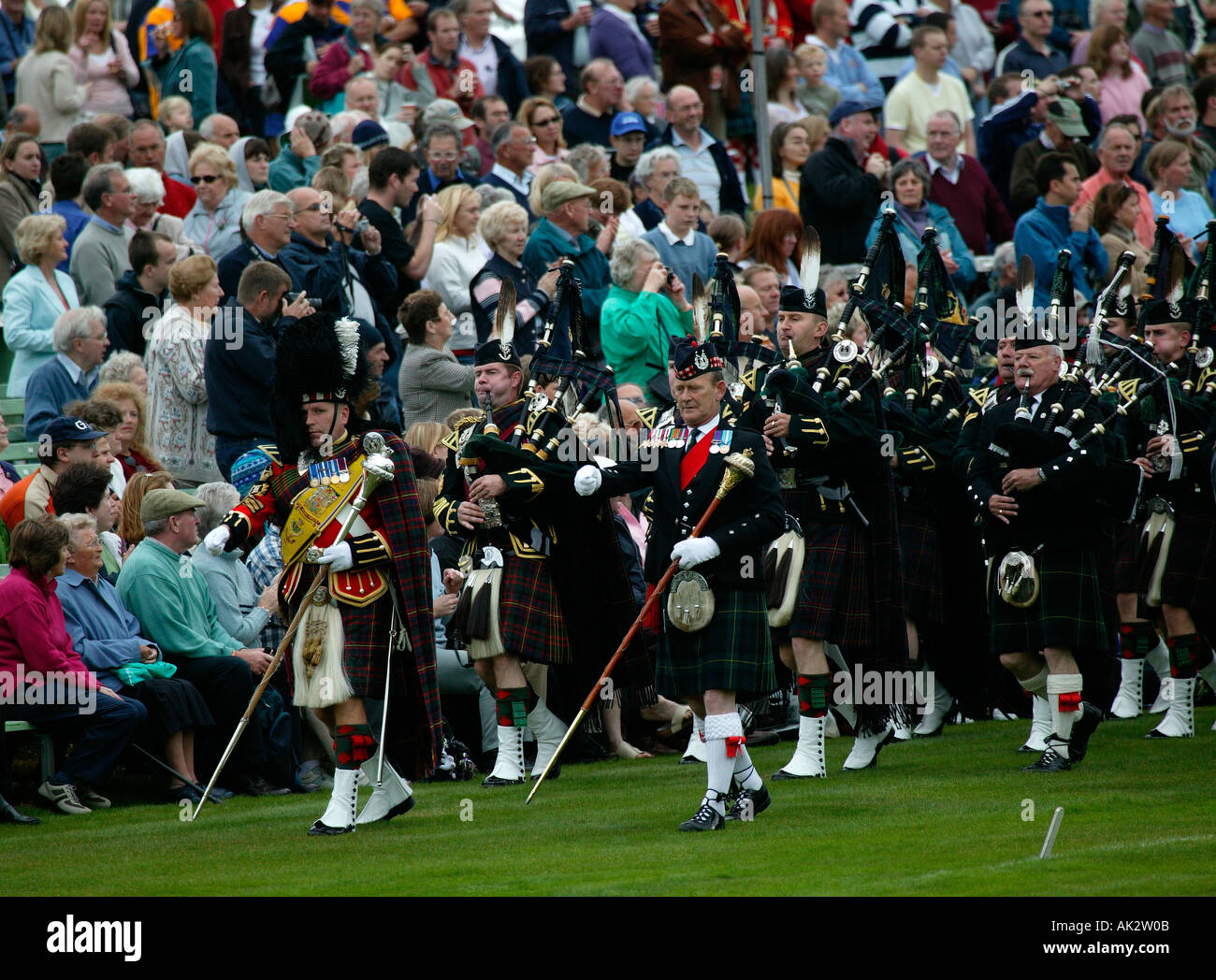 Collecte de Braemar Highland Games cornemuses défilent avec en arrière-plan de l'auditoire Banque D'Images