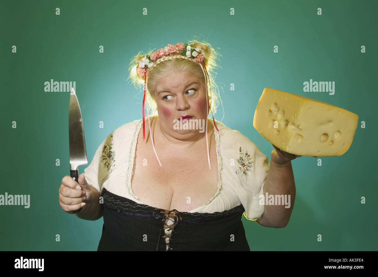 Femme tenant un couteau et un gros bloc de fromage Banque D'Images