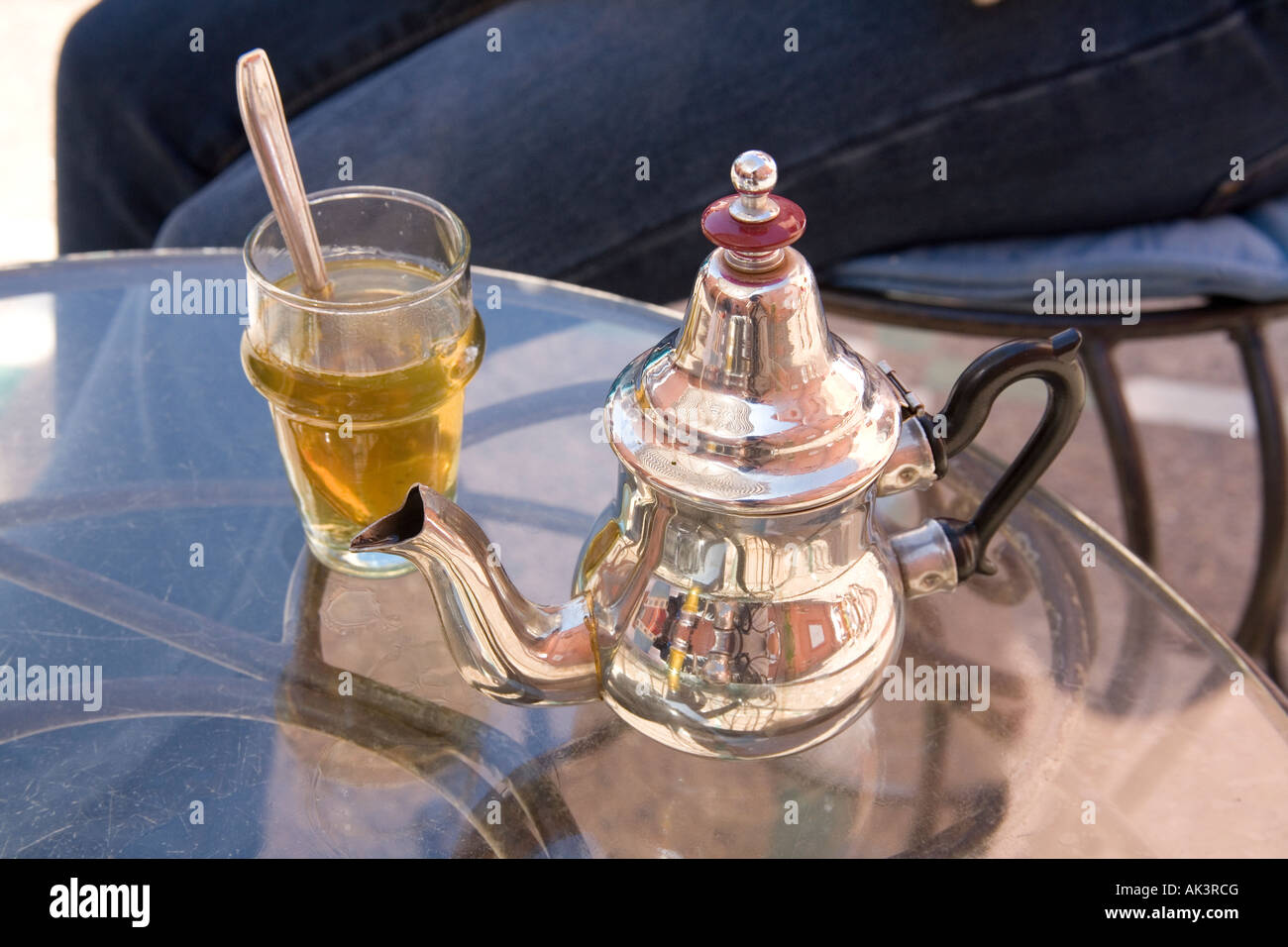 Verre de thé à la menthe marocain et l'argent théière. Marrakech Maroc. Banque D'Images