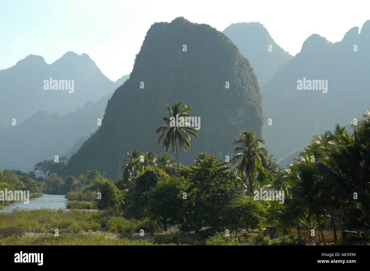 La rivière Nam Song avec palmiers et montagnes en forme de cloche près de Vang Vieng Laos Banque D'Images
