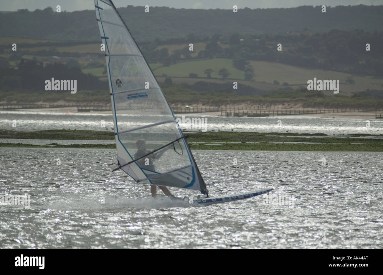 Planche à voile dans l'estuaire de la rivière Exe Dawlish Dawlish Warren avec en arrière-plan Grande-bretagne Devon Banque D'Images