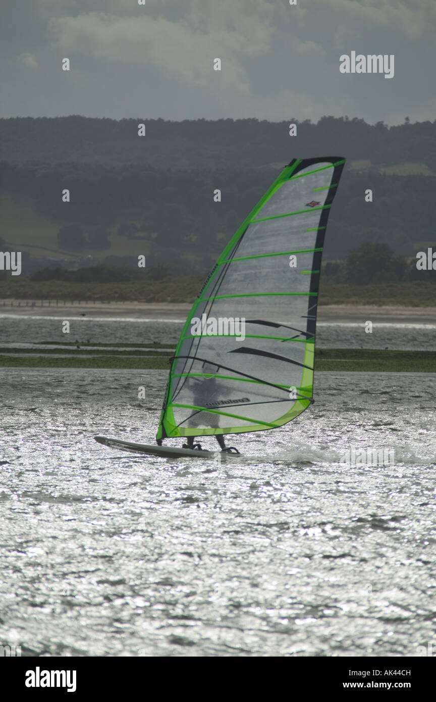 Planche à voile dans l'estuaire de la rivière Exe Dawlish Dawlish Warren avec en arrière-plan Grande-bretagne Devon Banque D'Images