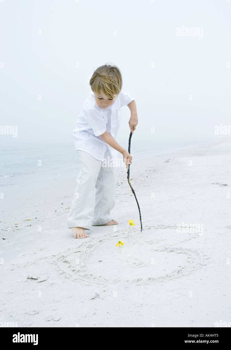 Petit Garçon Dessin Coeur Dans Le Sable à La Plage Banque D