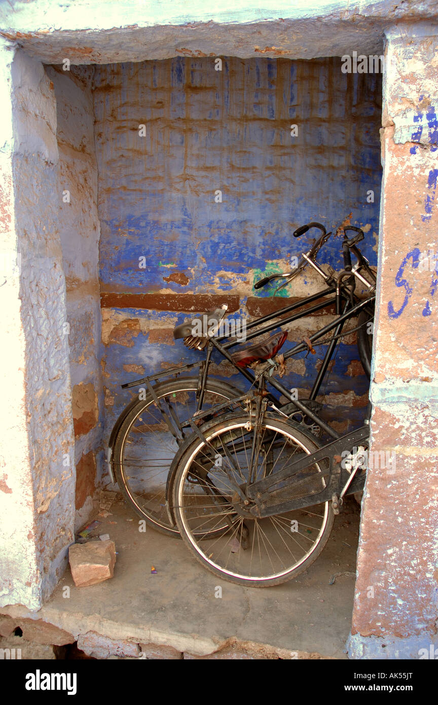 Deux vélos se penchant dans un hangar du ciment en Inde Banque D'Images