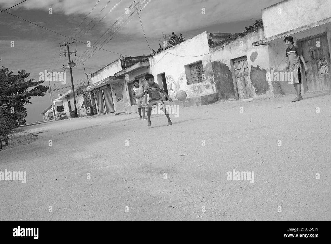 De jeunes garçons jouent au football dans la rue de willage Celestun Yucatan Mexique Banque D'Images