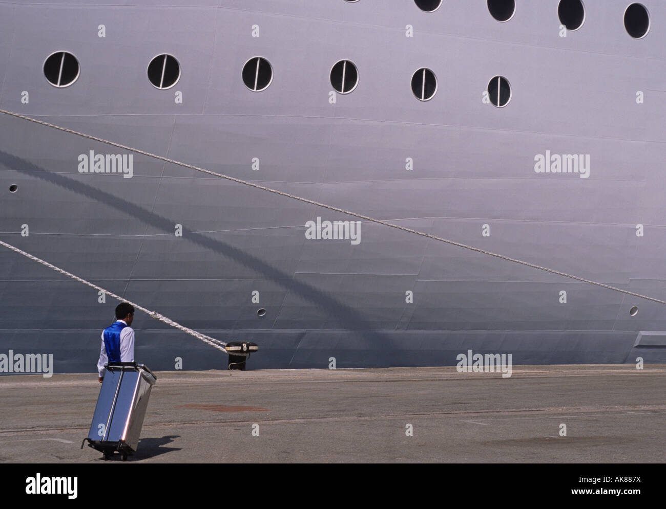 Un membre d'équipage avec une poubelle sur roues barrée d'une marche de la Cruiseship Banque D'Images