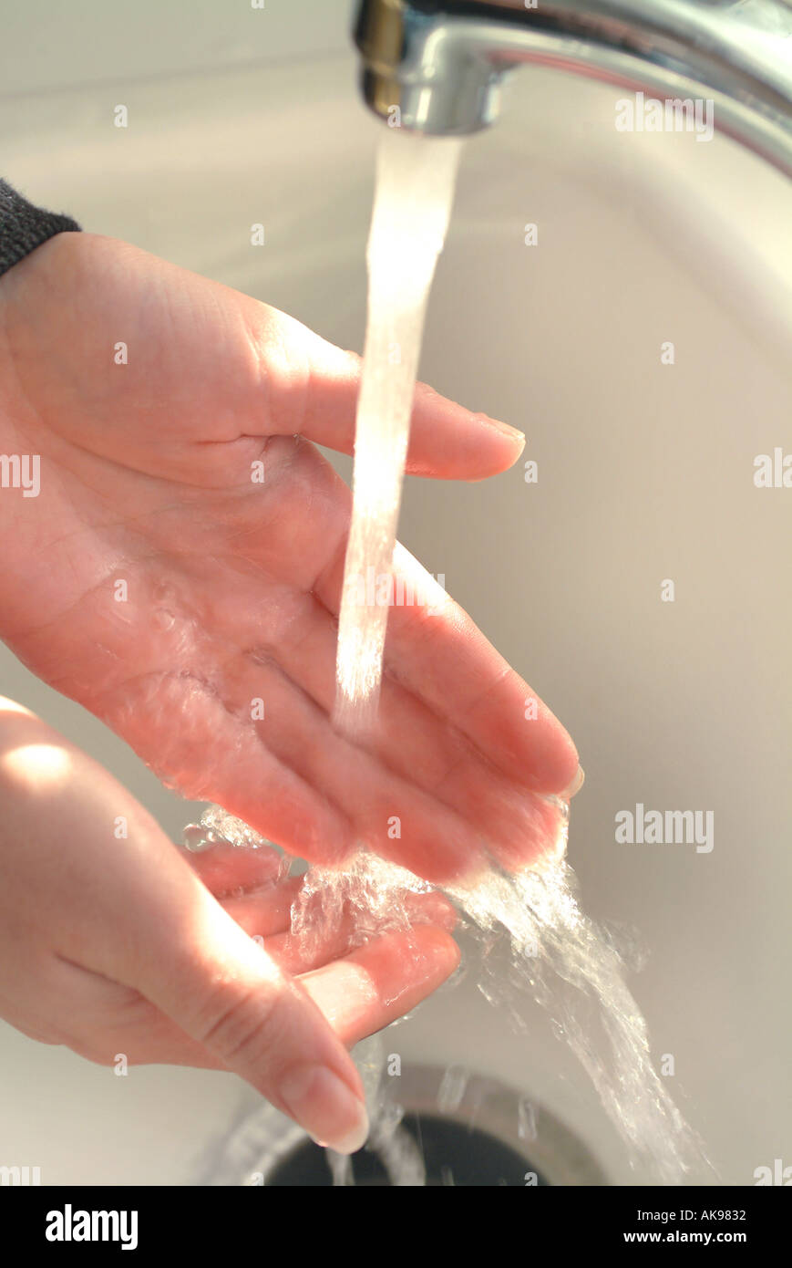 Les mains sous le robinet d'eau courante Banque D'Images