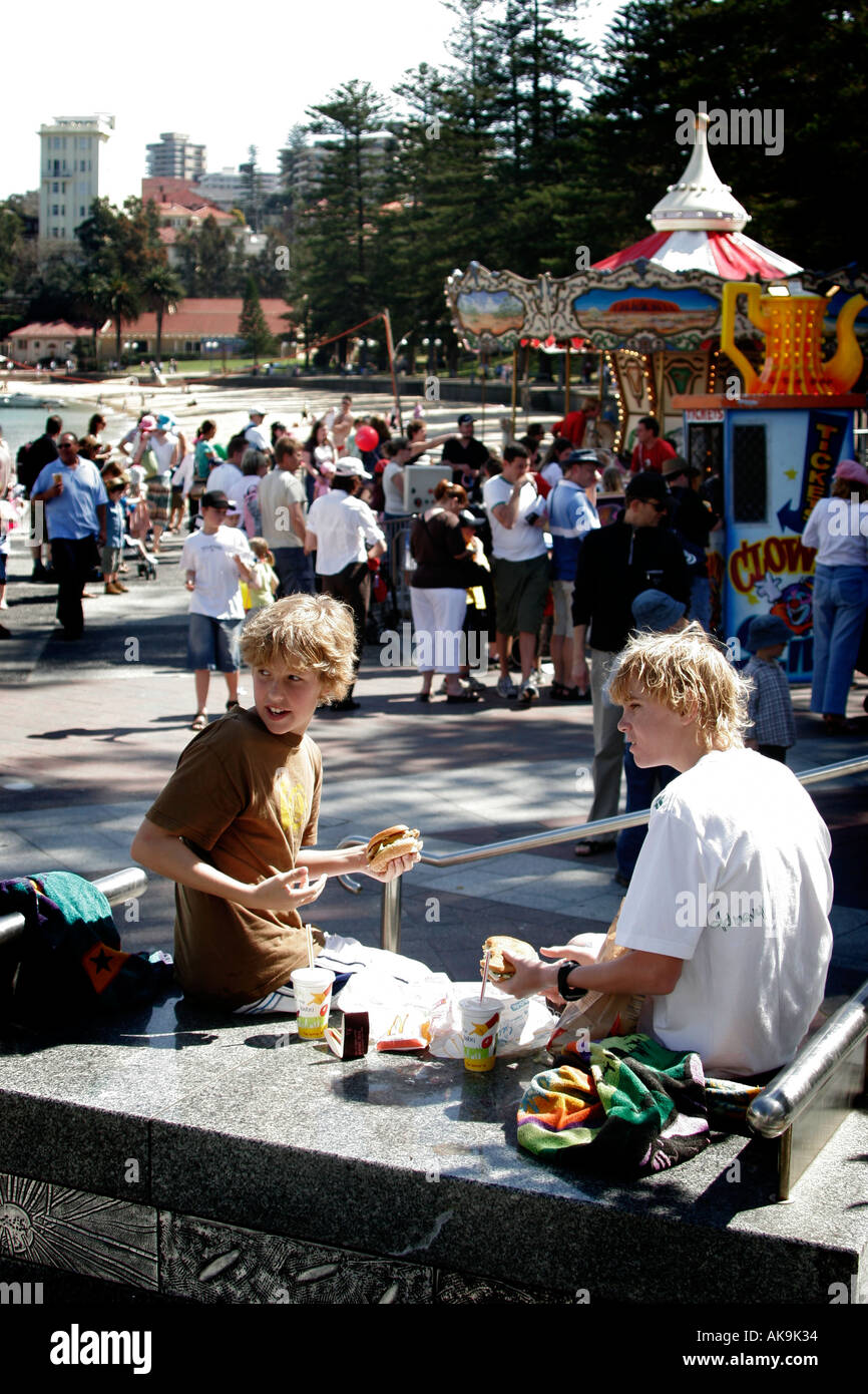 Les garçons mangent de la nourriture à emporter dans une station juste à Manly, Australie Banque D'Images