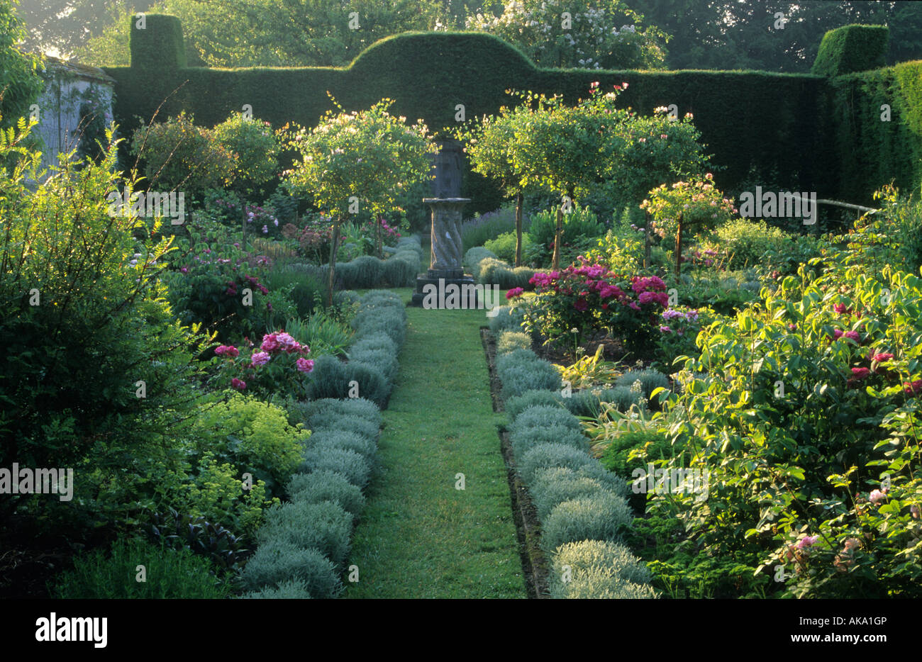 Cranbourne Dorset Manor avec un jardin de fines herbes formelle bordée de lavande herbe chemin menant à cadran solaire point focal et une formation standard Banque D'Images