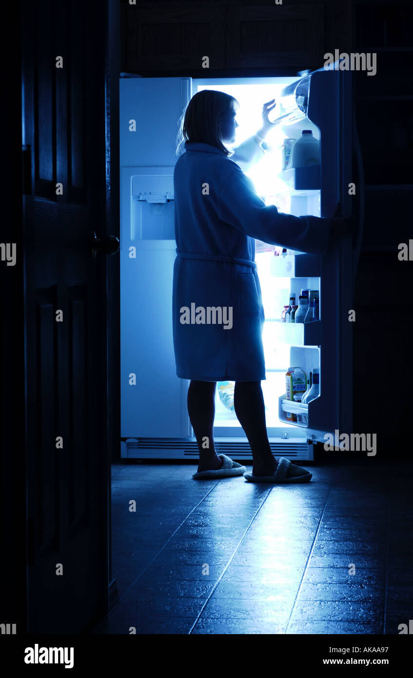 Ouverture d'un réfrigérateur femme midnight snack Banque D'Images