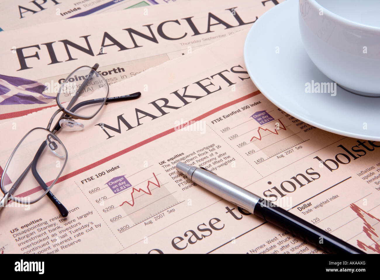 Journal financier d'étudier les actions et les marchés financiers pour les gagnants avec une tasse de thé et des spectacles de plumes Banque D'Images