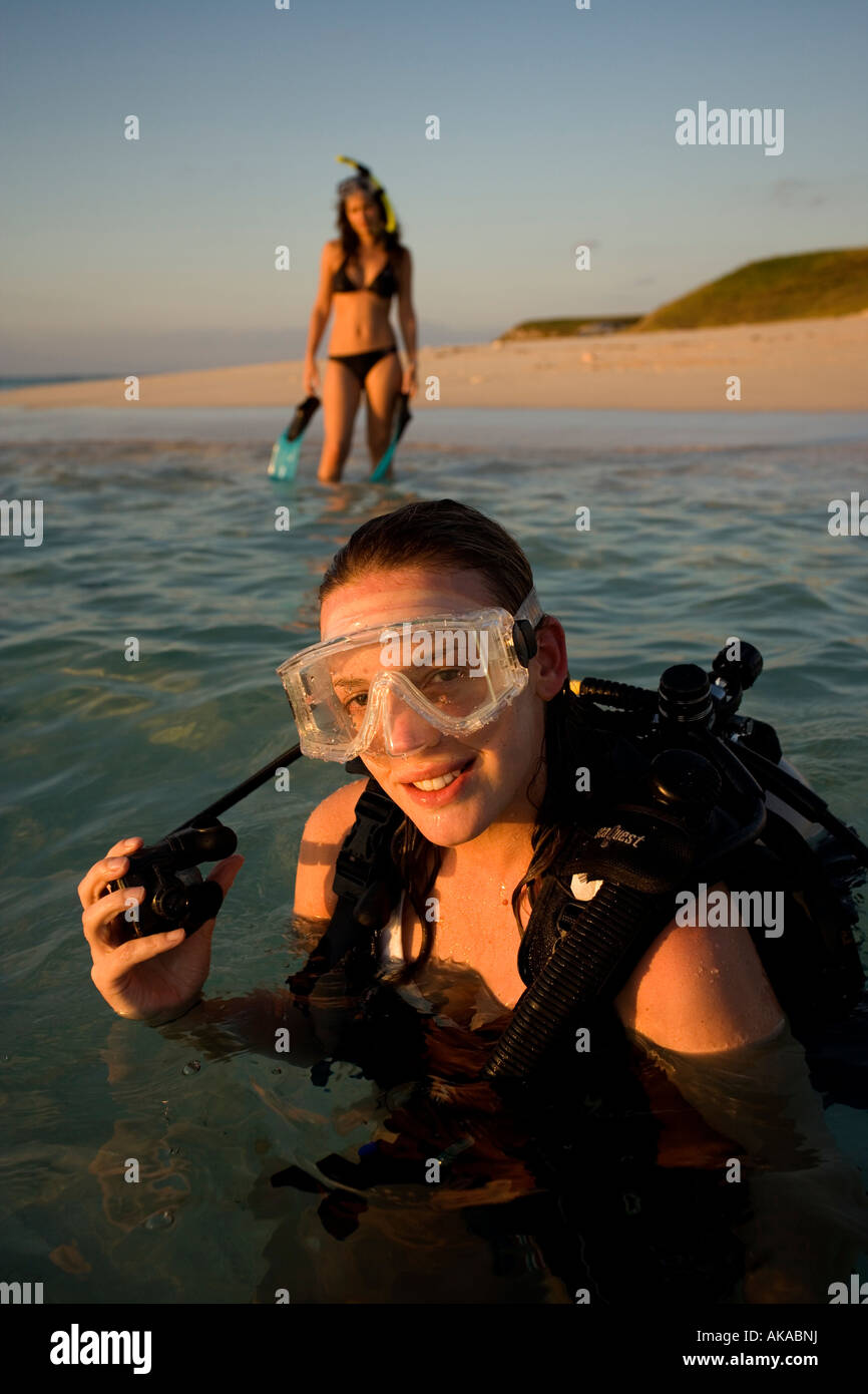 Deux jeunes filles profitez de l'attrait de l'océan en entrant dans les eaux à Gibb's Cay, Îles Turks et Caicos. Banque D'Images