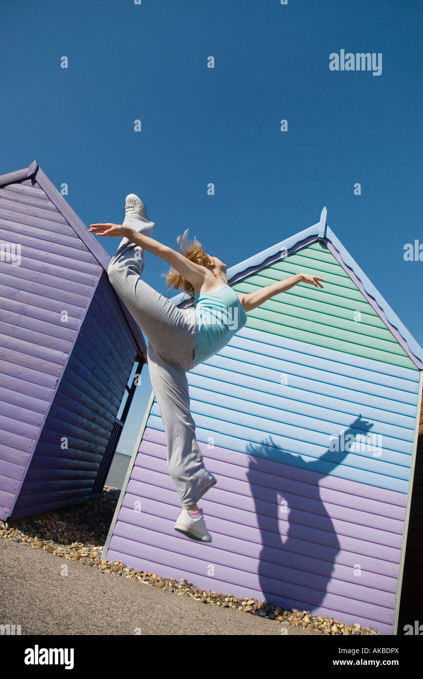 Femme de sauter devant beach hut Banque D'Images