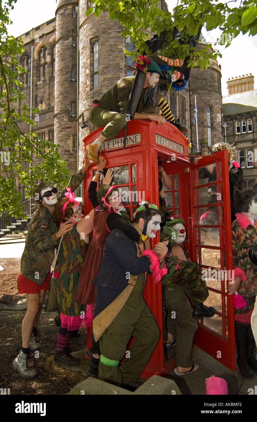 Plusieurs personnes habillés en clown à l'intérieur d'une boîte de téléphone rouge Banque D'Images
