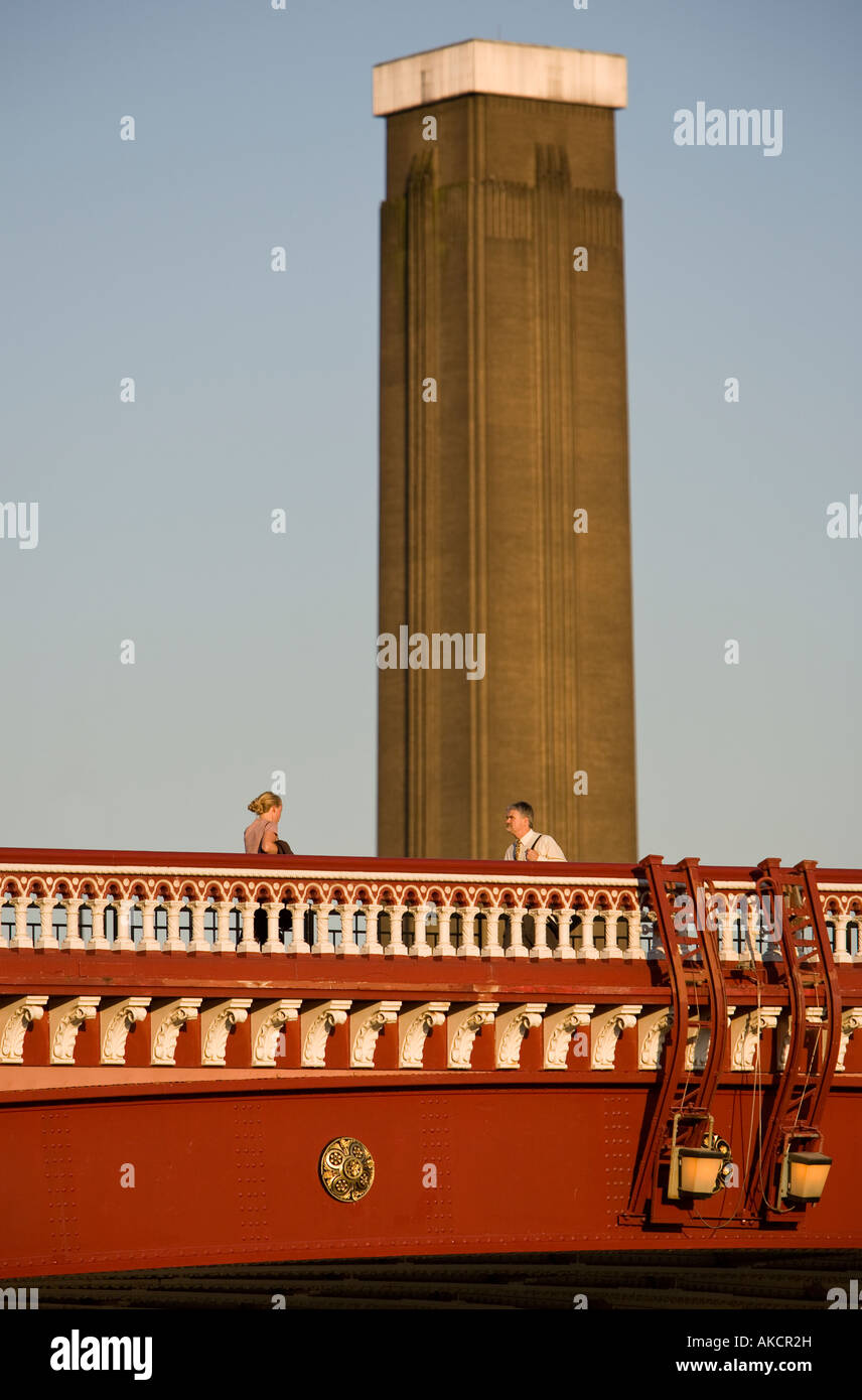 Un homme et une femme crossing Blackfriar's bridge avec la Tate Modern art gallery de l'arrière-plan. Londres, Angleterre. Banque D'Images