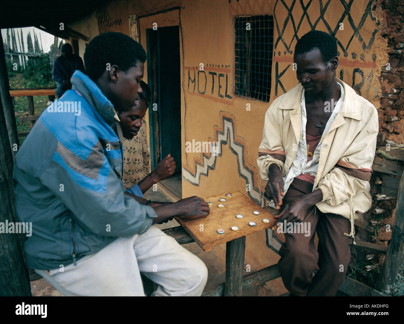 Deux hommes africains locaux jouer les dames avec bouteilles Embobout l'Afrique de l'ouest du Kenya Banque D'Images