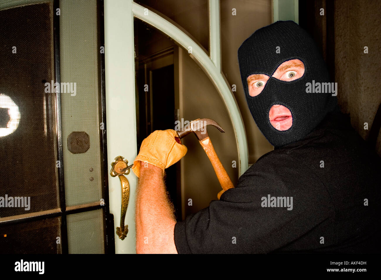 Un cambrioleur de voler une maison portant une cagoule. Banque D'Images