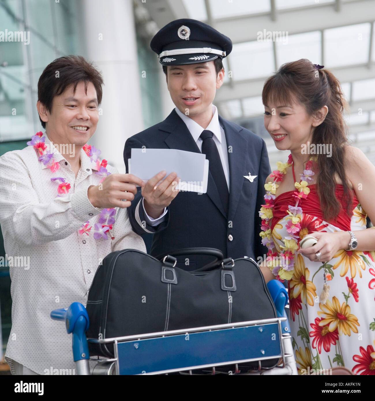 Couple mature montrant leurs billets d'avion d'un pilote Banque D'Images