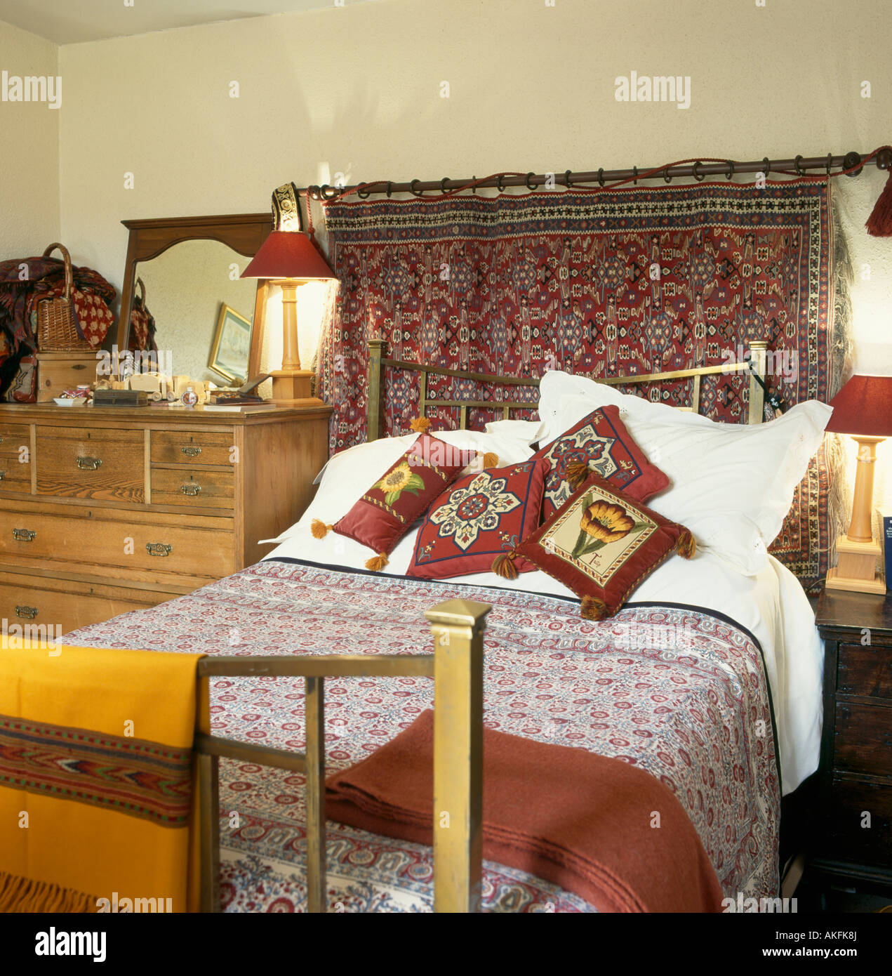 Tenture murale indien au-dessus de lit en cuivre avec des coussins et  couvre-lit rouge en petite chambre à coucher Photo Stock - Alamy