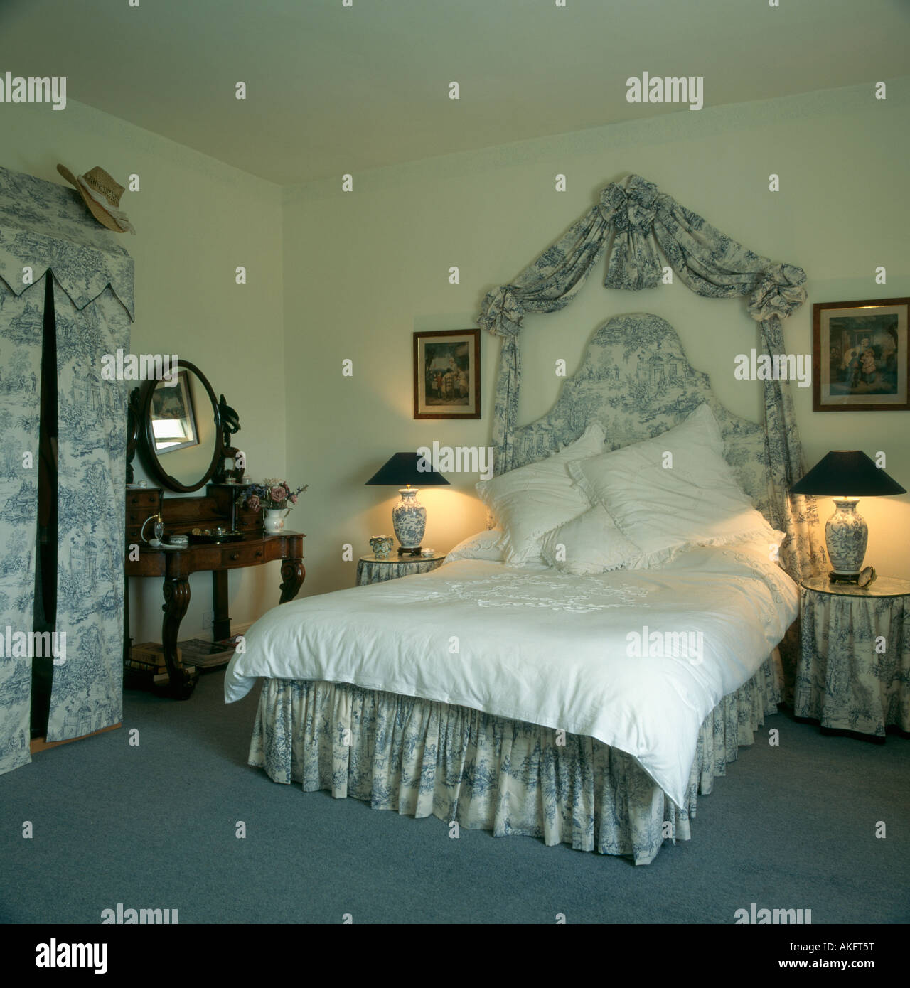 Lit avec toile de Jouy bleu tissu drapé au-dessus de lit correspondant et  valence dans chambre avec des lampes allumées Photo Stock - Alamy