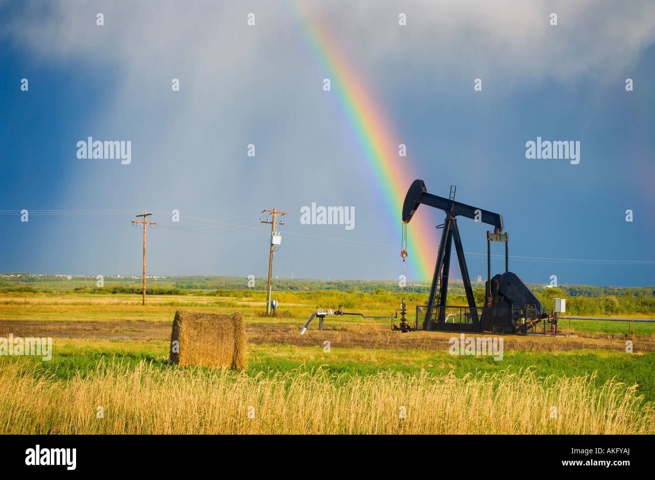 Les nuages de tempête et arc-en-ciel sur la pompe à huile des prairies Banque D'Images