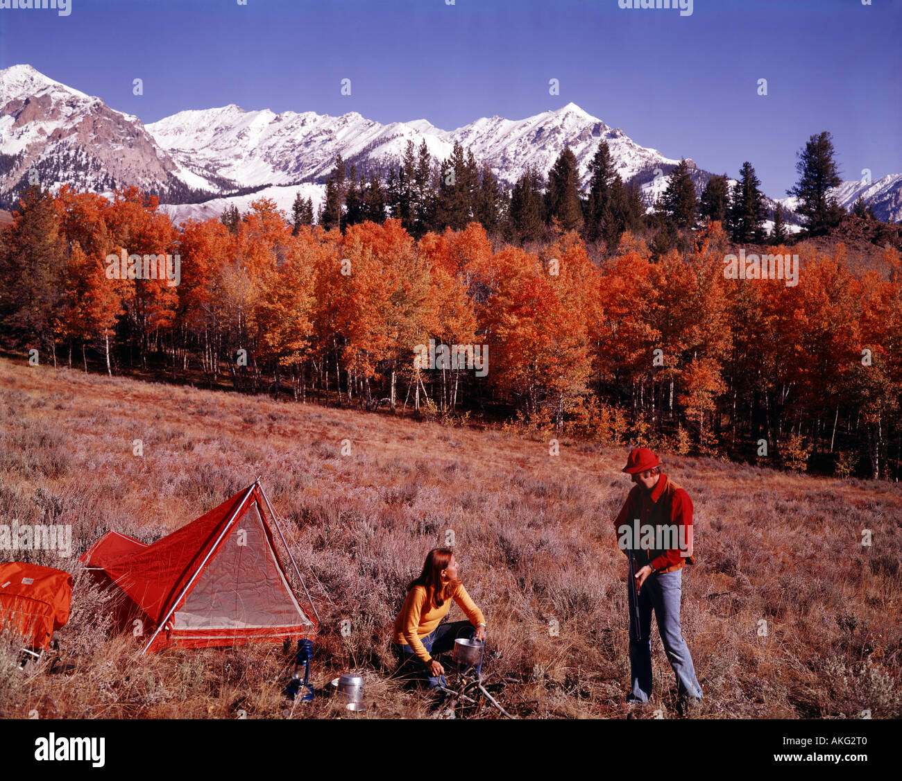 Jeune couple établir le campement sur une expédition de chasse pour les hautes montagnes de l'Idaho où sommets enneigés montée à l'horizon Banque D'Images