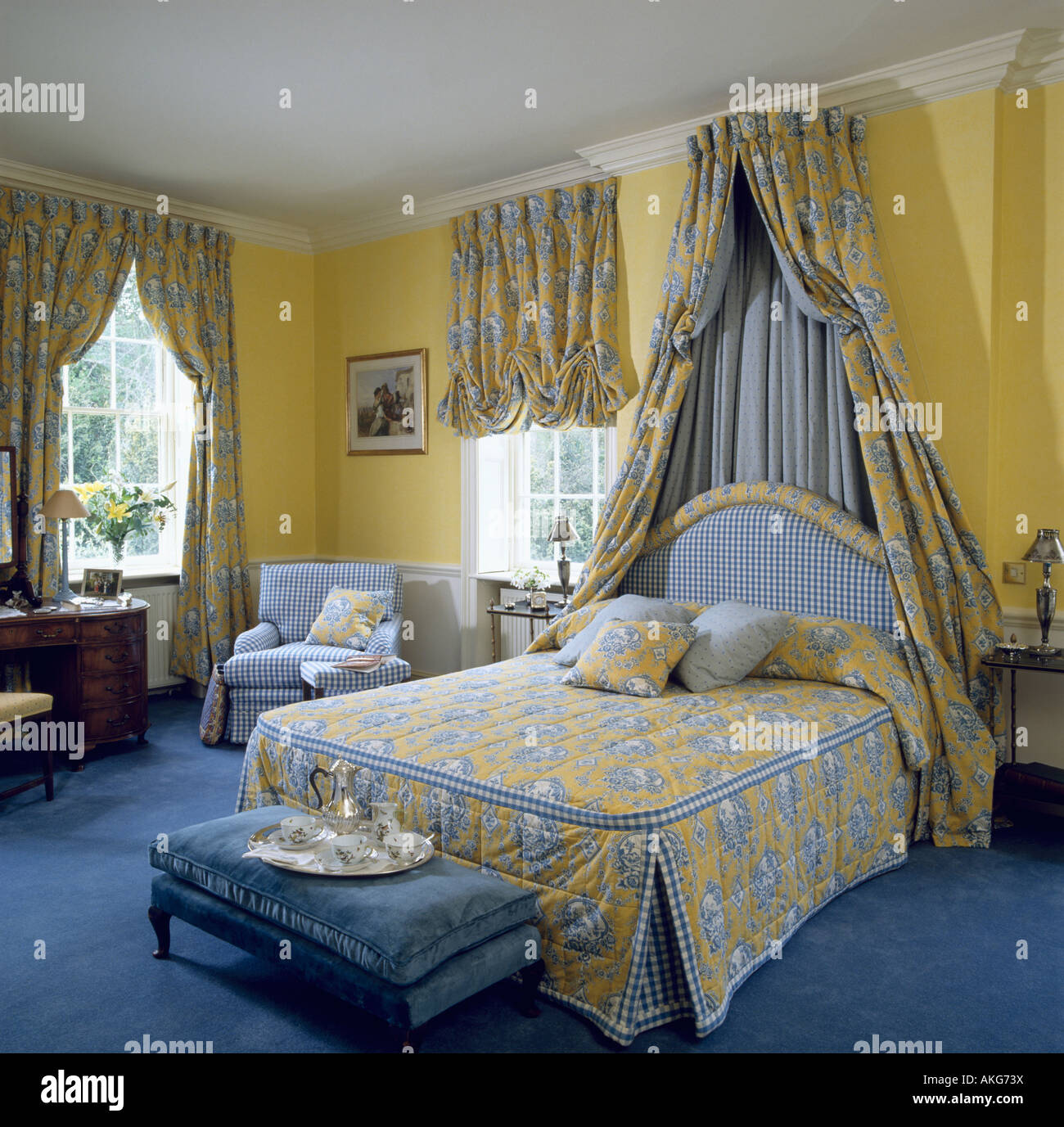 Jaune et bleu sur la couverture à motifs lit double avec rideaux sur  coronet en jaune traditionnel chambre avec tapis bleu Photo Stock - Alamy