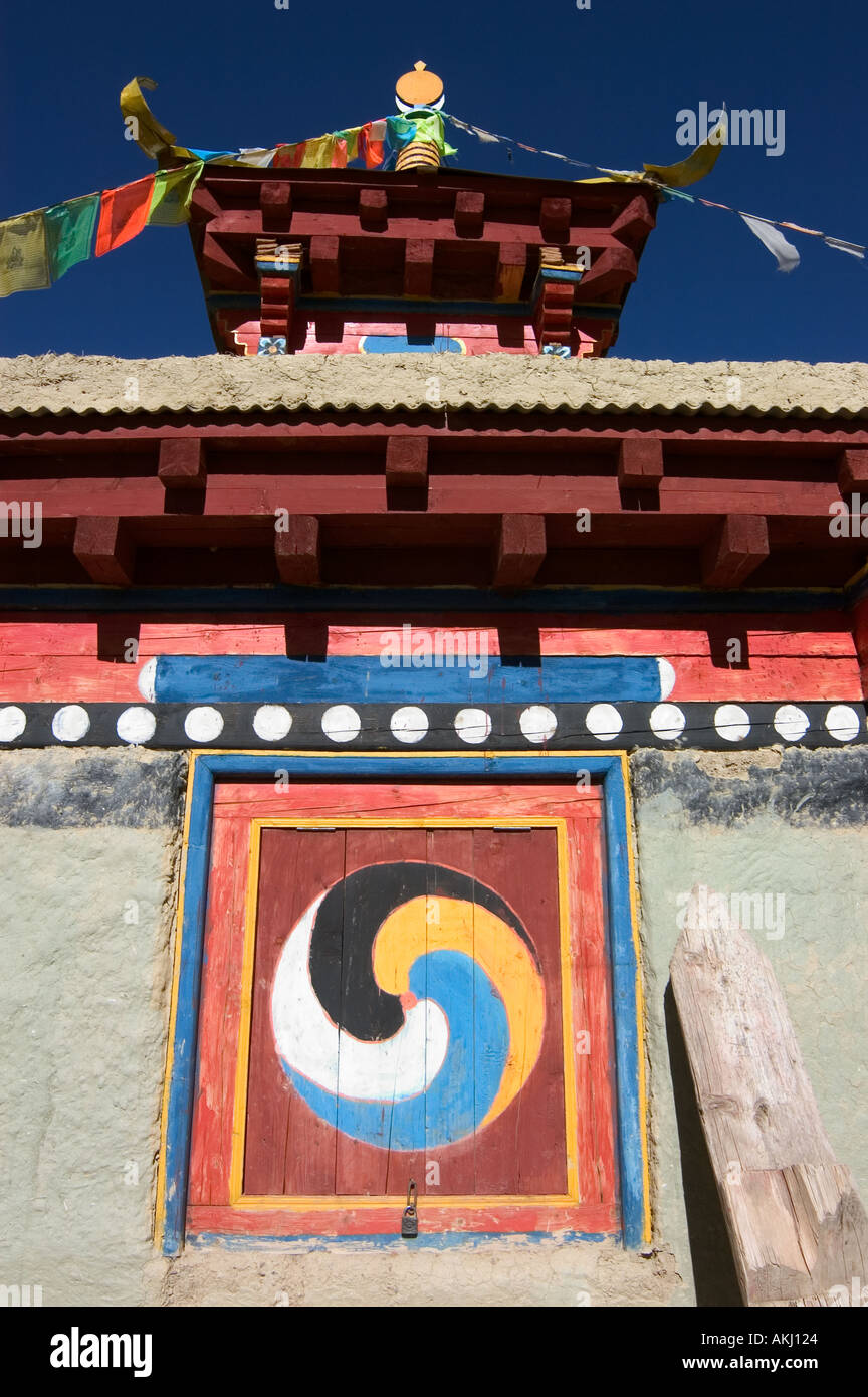 Les drapeaux de prières volent d'un chorten stupa décoré avec le symbole Yin Yang une relique Bouddhiste Tibétain Kham titulaire Tibe Orientale Banque D'Images