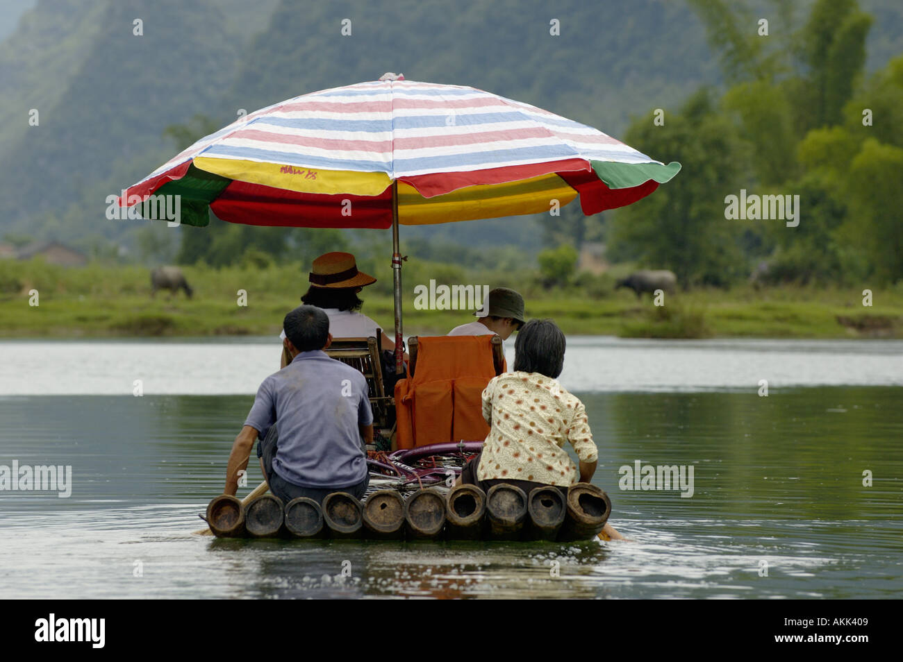 La Chine, Guangxi, Yangshuo - une famille chinoise de l'aviron sur un radeau de bambou sur la rivière Yulong Banque D'Images