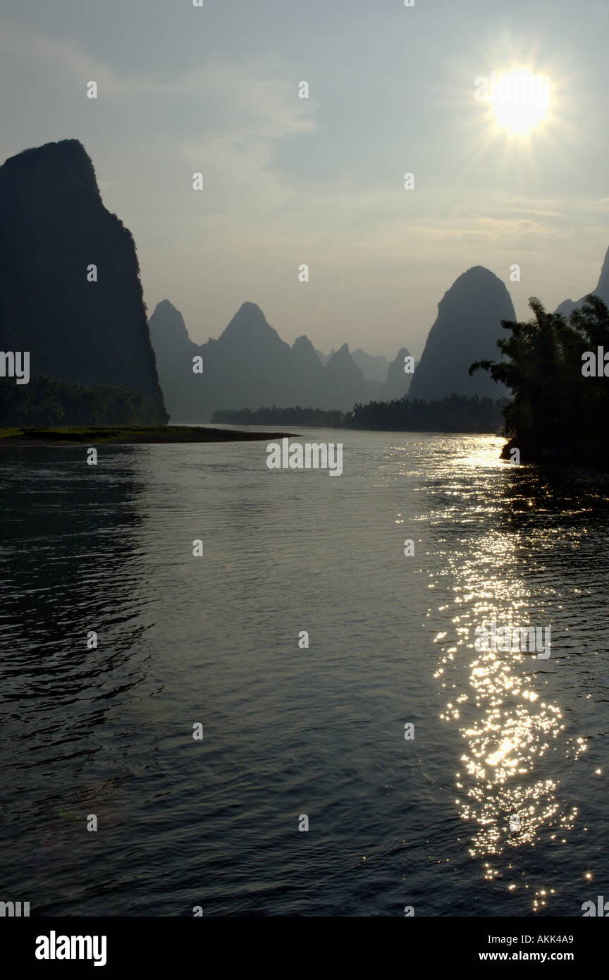 Chine Guangxi calcaire au coucher du soleil entre Xinping et Yangshuo sur Rafting sur la rivière - comme le soleil se couche Banque D'Images