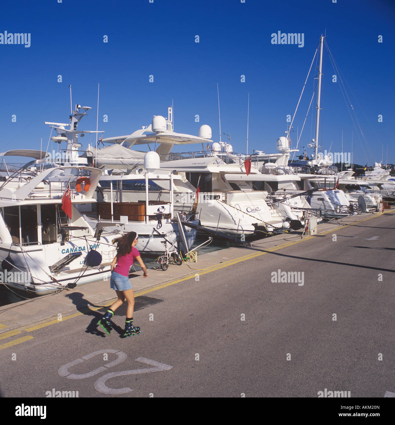 En Scène de plaisance Alcudiamar avec jeune femme en ligne patineuse et yachts, Puerto Alcudia, au Nord Est de Majorque. Banque D'Images