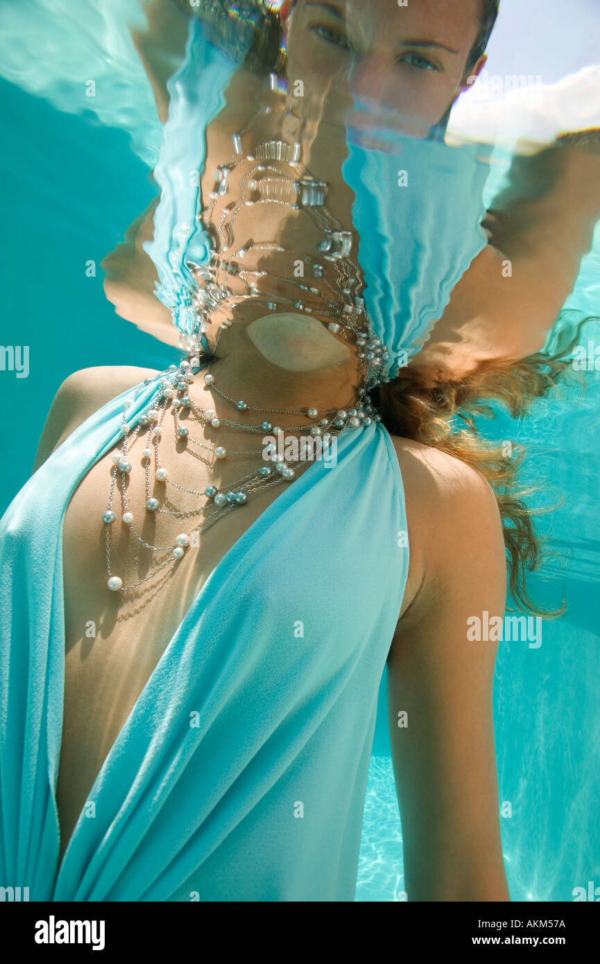 La femme en bleu robe et collier argent underwater Banque D'Images