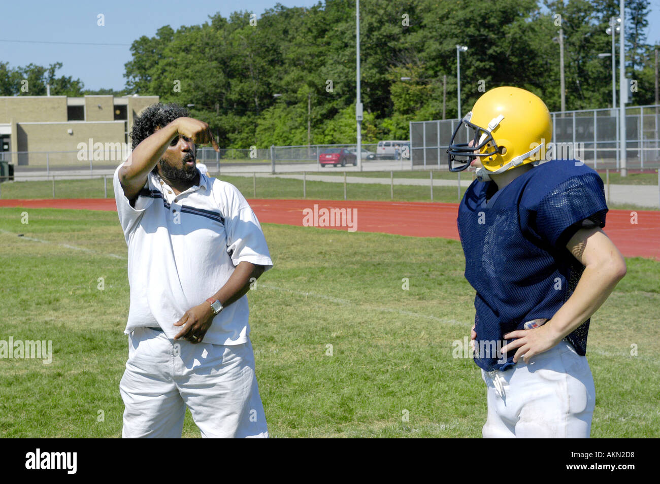 L'action de l'école de football de haut Port Huron au Michigan football player lit JV Sourds la langue des signes donnés par l'aide au cours de la pratique noir Banque D'Images