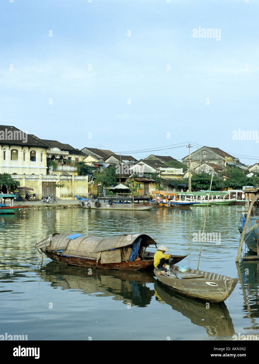 De petites embarcations sur la rivière Thu Bon et vieux bâtiments sur St Bach Dang, considérée dans une île, Hoi An Hoi An, Viet Nam Banque D'Images