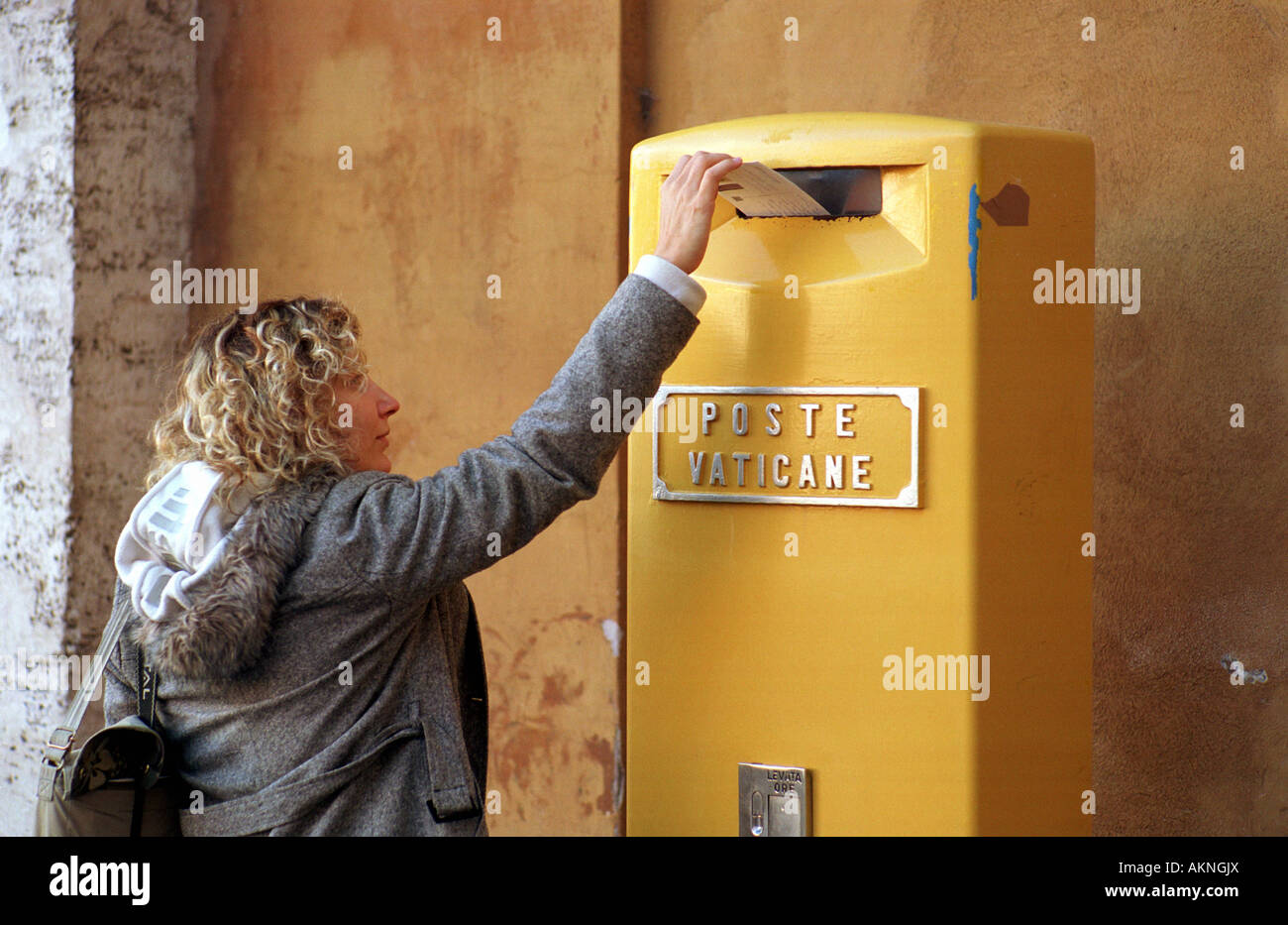 Woman throwing son courrier dans une boîte aux lettres de la poste du Vatican Banque D'Images