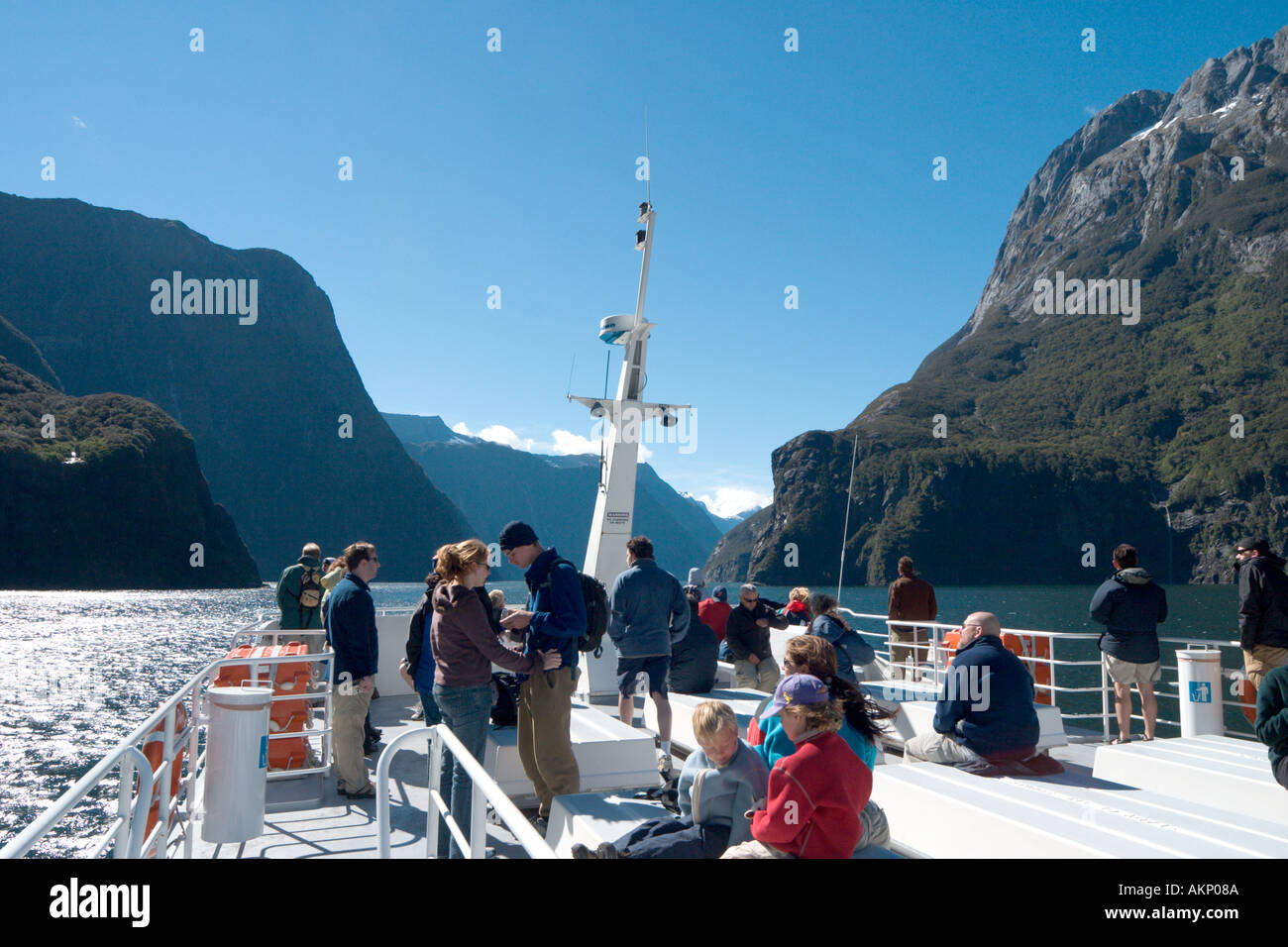 Milford Sound, Nouvelle-Zélande. Touristes sur le pont d'une croisière en bateau rouge, Milford Sound, parc national de Fiordland, île du Sud, Nouvelle-Zélande Banque D'Images