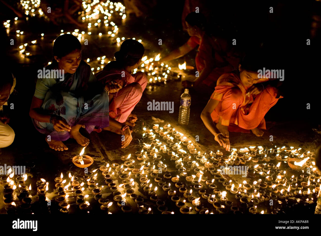Les femmes et les filles indiennes des lampes à l'huile d'éclairage dans un temple hindou à un Diwali festival à Puttaparthi, Andhra Pradesh, Inde. Festival hindou des lumières Banque D'Images