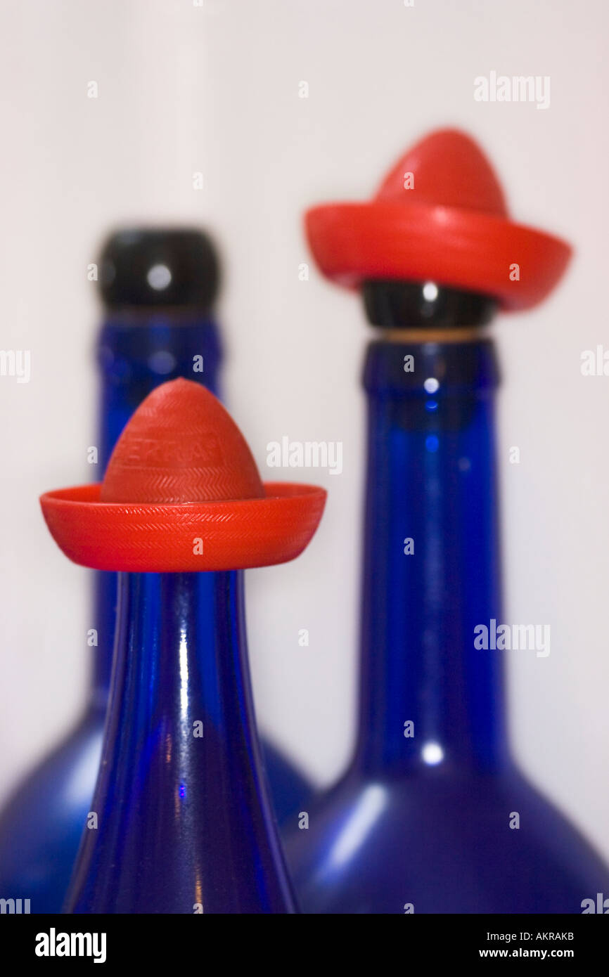 Sherry verre bleu portant des bouteilles en plastique rouge chapeaux mexicains trouvés sur certaines marques de tequila Banque D'Images